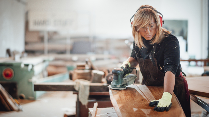 woman carpenter finishing table